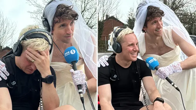 Greg James in a wedding dress holding a Radio 1 mic while Jamie looks cheered up by his appearance