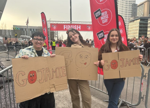 Three women holding signs