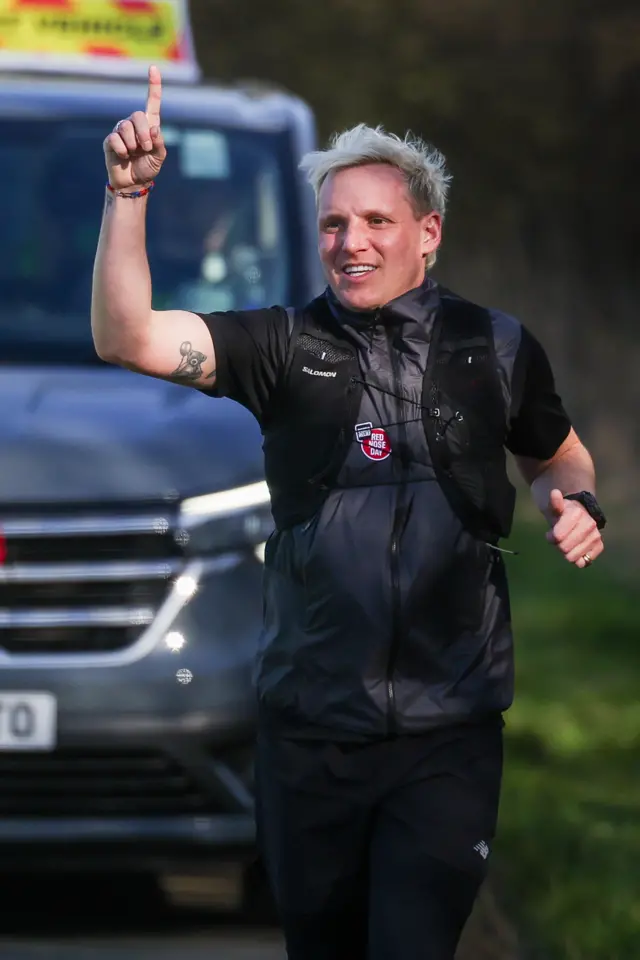 Jamie Laing points to the sky on Day 4 of his ultra marathon challenge