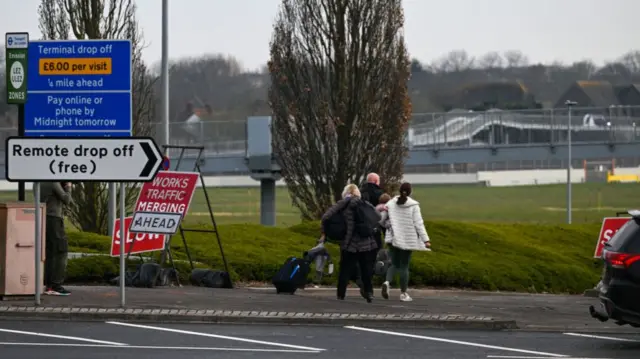 People drag suitcases to Heathrow Airport