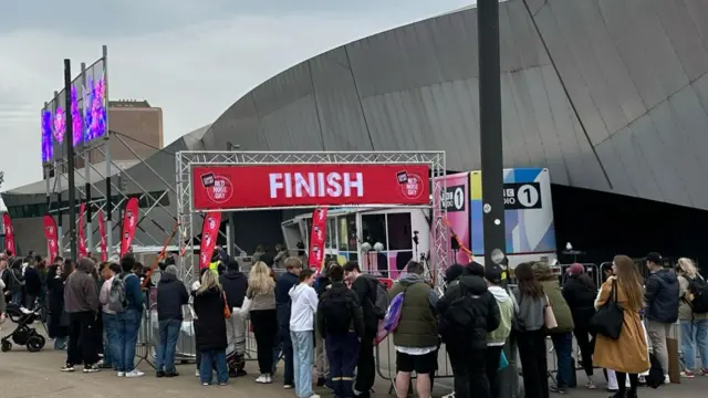 A crowd gathers at the finish line in Salford