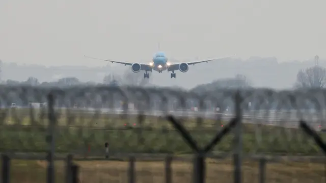 A front view of a plane as it descends to the runway