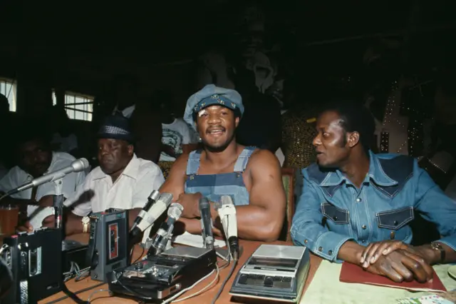 Heavyweight boxing champion George Foreman holds a press conference in Kinshasa, Zaire, on September 18th, 1974. His trainer Sandy Saddler is seated on the left