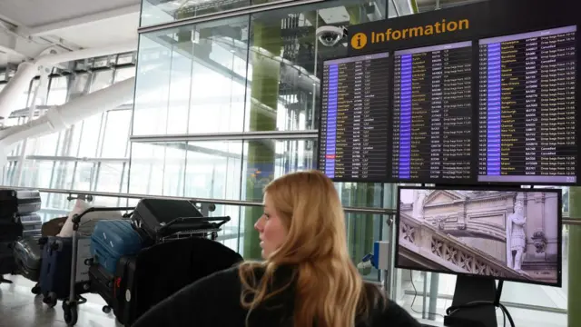 A screen displays flight information at Terminal 5 of the Heathrow International Airport