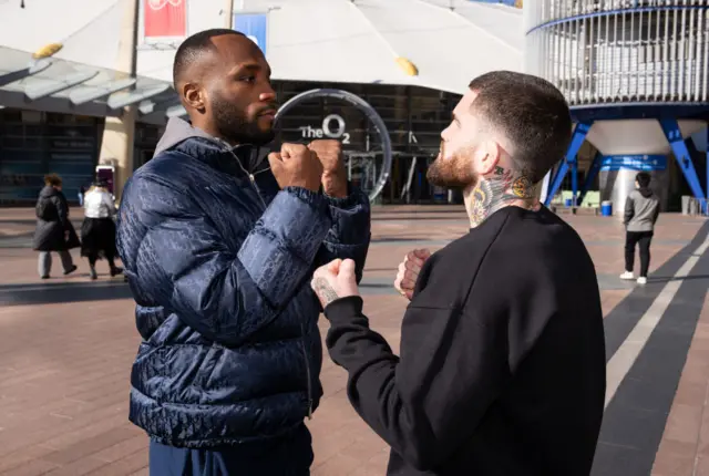 Leon Edwards and Sean Brady stand face to face with their fists up outside the O2 Arena in London