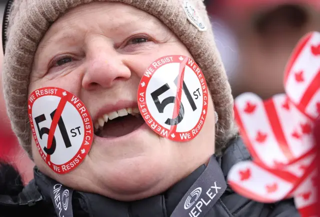 Woman with stickers on her face, stickers have the number 51 crossed off