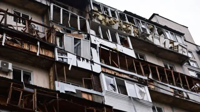 The face of an apartment block, which shows damage on windows and balconies