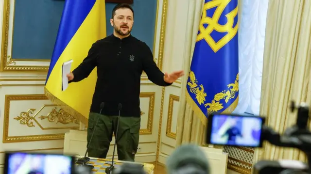 Volodymyr Zelensky gestures as he speaks to reporters in Kyiv.