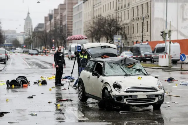 A damaged white Mini on a rainy street in Munich