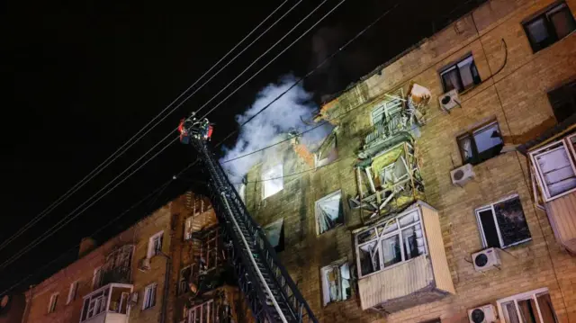 Emergency services attending a residential building in Kharkiv, Ukraine, after it was hit by a Russian drone
