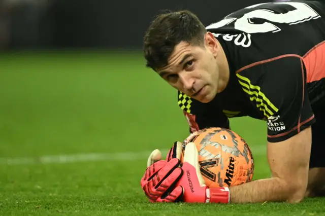 Emiliano Martinez holds the ball