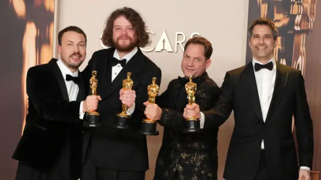 Gints Zilbalodis, Matīss Kaža, Ron Dyens, and Gregory Zalcman pose for pictures holding their Oscars
