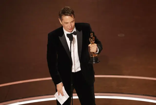 Sean Baker holding his Oscar