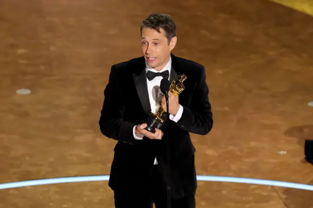 Sean Baker holding his Oscar