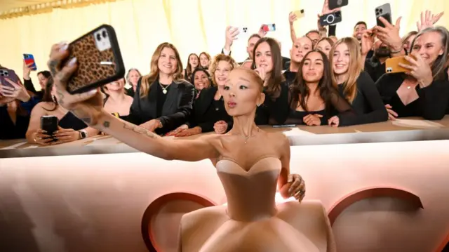 Ariana Grande taking a selfie with fans