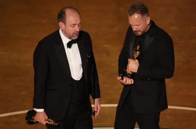 Nathan Crowley and Lee Sandales accept the Oscar for Best Production Design for "Wicked"