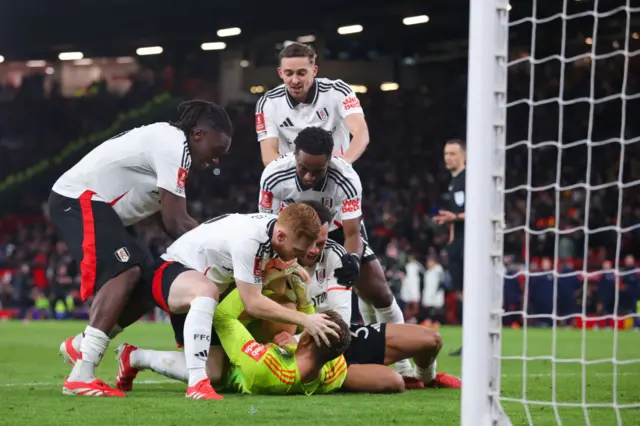 Fulham's players celebrate with goalkeeper Bernd Leno after beating Manchester United on penalties