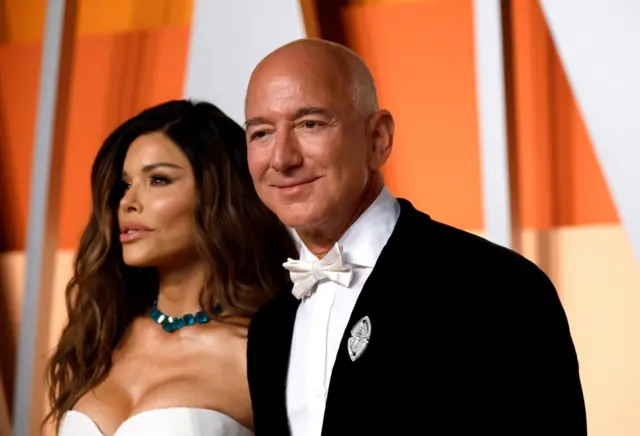 Lauren Sanchez and Jeff Bezos arrive at the Vanity Fair Oscars party, both dressed in white