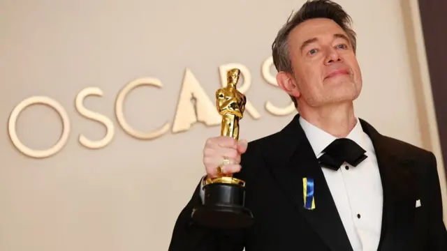 Peter Straughan poses with the Best Adapted Screenplay for "Conclave" award in the Oscars photo room