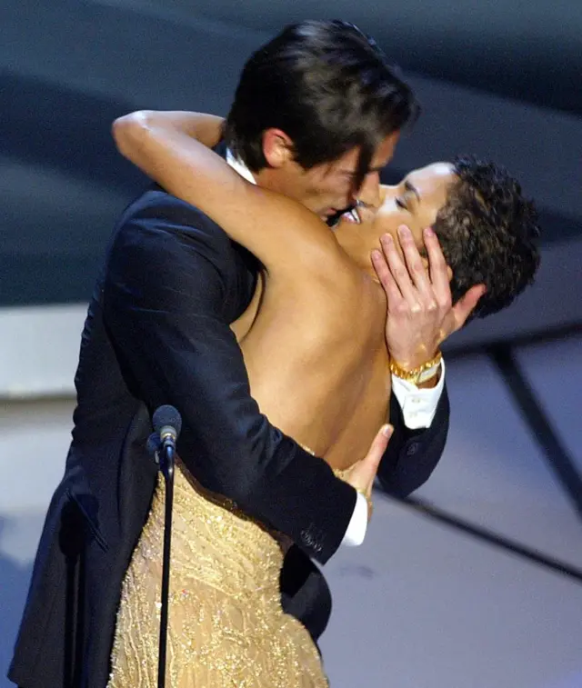 Adrien Brody kissing Halle Berry in a backless gold sequined dress