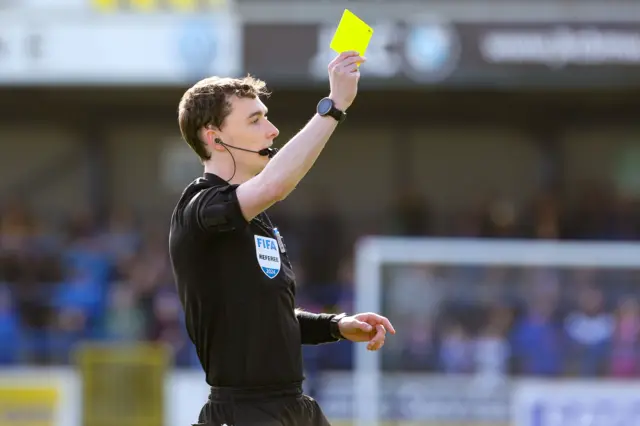 Ben McMaster shows a yellow card