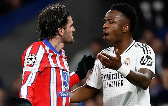 Real Madrid's Vinicius Junior (R) in action against Atletico Madrid's Rodrigo de Paul