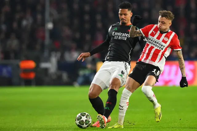 William Saliba (L) fights for the ball with PSV Eindhoven's Dutch forward Noa Lang