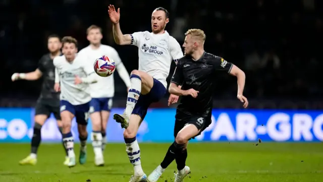 Preston's Will Keane takes on Swansea defender Harry Darling