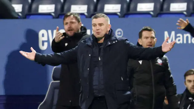 Bolton boss Steven Schumacher stands with arms outstretched