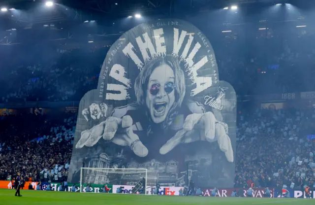 Villa fans hold up a display of Ozzy Osbourne in the Holte End