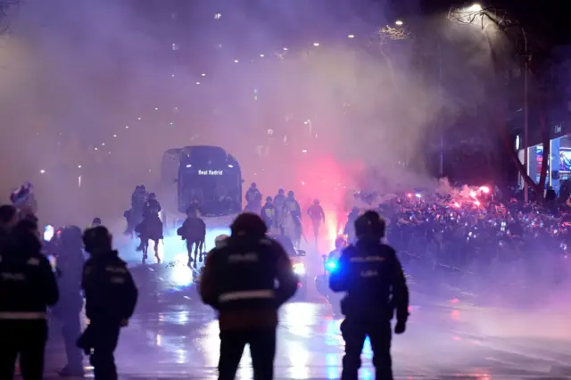 Real Madrid team coach with fans holding flares