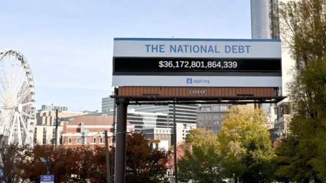 The US has a big national deficit - the difference between annual income and spending - and a big national debt, as this "debt clock" in Atlanta, Georgia shows (picture taken 4 December 2024)