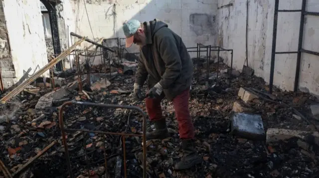 A resident stands inside a house destroyed by a Russian drone strike in Odesa