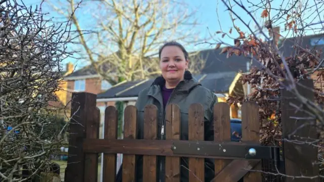 Laura Archer by a gate