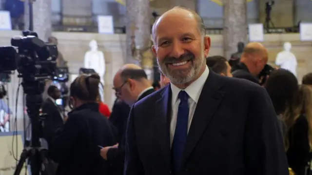 Commerce secretary Howard Lutnick smiling in a suit