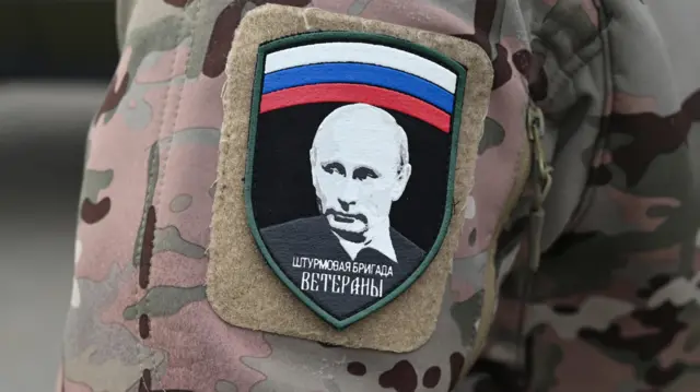 Russian service member wears patch carrying Russian flag and president Vladimir Putin