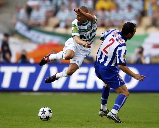 Henrik Larsson of Celtic is sent flying by the challenge from Jorge Costa