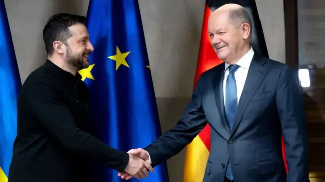 German Chancellor Olaf Scholz (R) and Ukrainian President Volodymyr Zelensky (L) shake hands as they meet for talks at the Munich Security in early 2025