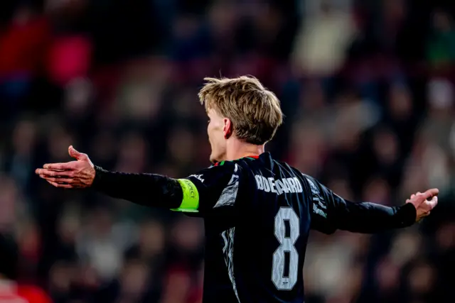 Martin Odegaard stands with his arms out