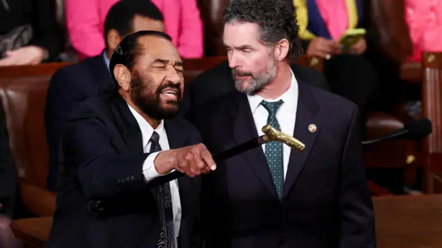 Al Green holding a cane shouting