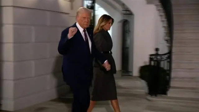 President Donald Trump exits the White House with his wife, Melania