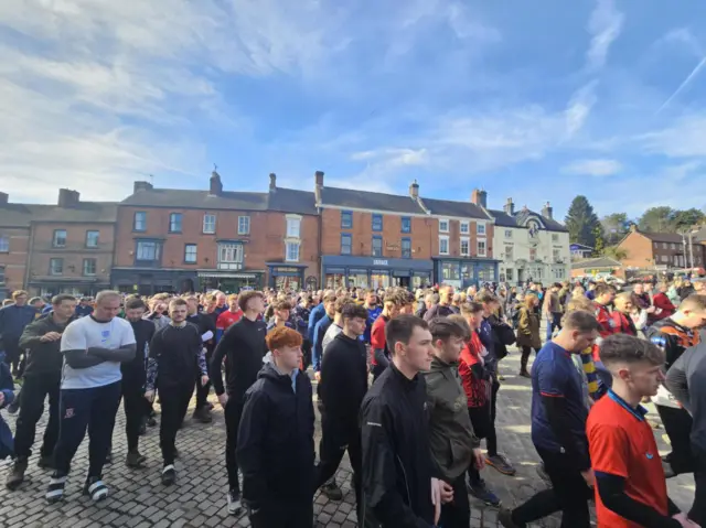 A crowd of people in the market place