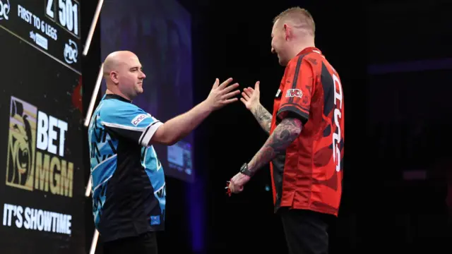 Rob Cross shakes hands with Nathan Aspinall in the Premier League semi-final