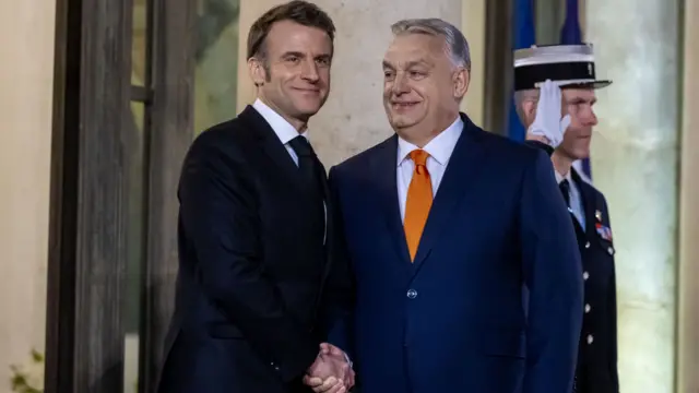 French President Emmanuel Macron shakes the hand of Hungary's Prime Minister Viktor Orban.