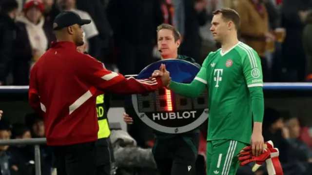 Manuel Neuer shakes the hand of Bayern manager Vincent Kompany as he is substituted