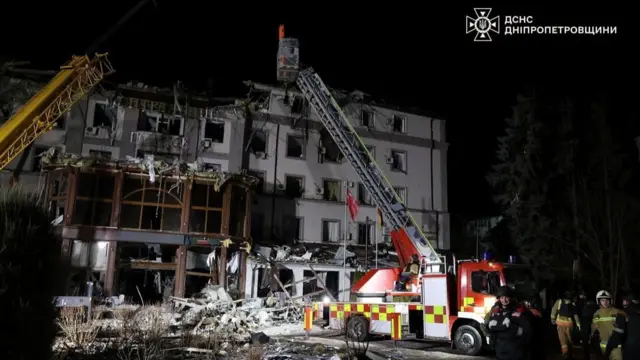 Rescue operations at hotel struck overnight, a fire truck operating a crane to inspect the top of the building