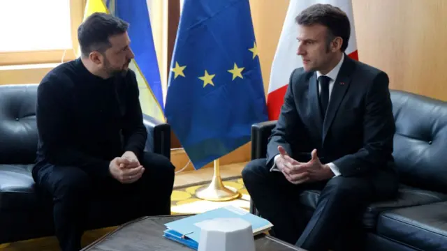 Ukraine's President Volodymyr Zelensky sat on a black leather sofa opposite France's President Emmanuel Macron