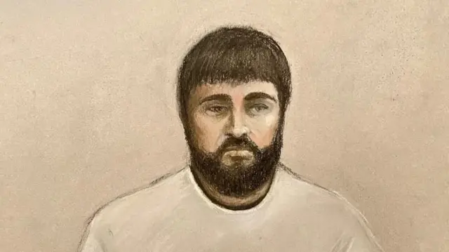 Clifford court drawing wearing a white sweater and with a neatly trimmed full beard and moustache, he looks zoned out and unhappy