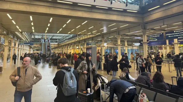 A crowd stands at King's Cross Station