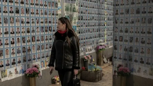 A woman visits the "The Wall of Remembrance of the Fallen for Ukraine", a memorial for fallen Ukrainian soldiers, in downtown Kyiv